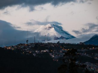 town with lights far from mountain field with snow by multimaniaco (Unsplash.com)