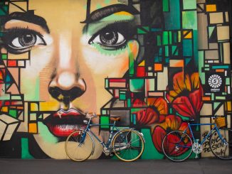 Bikes lean against wall painting by timon_k (Unsplash.com)