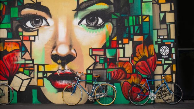 Bikes lean against wall painting by timon_k (Unsplash.com)