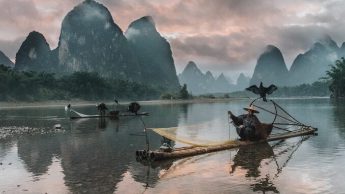 Sunset on the Li River as the few remaining cormorant fisherman pack their nets for the night. by sam_beasley (Unsplash.com)